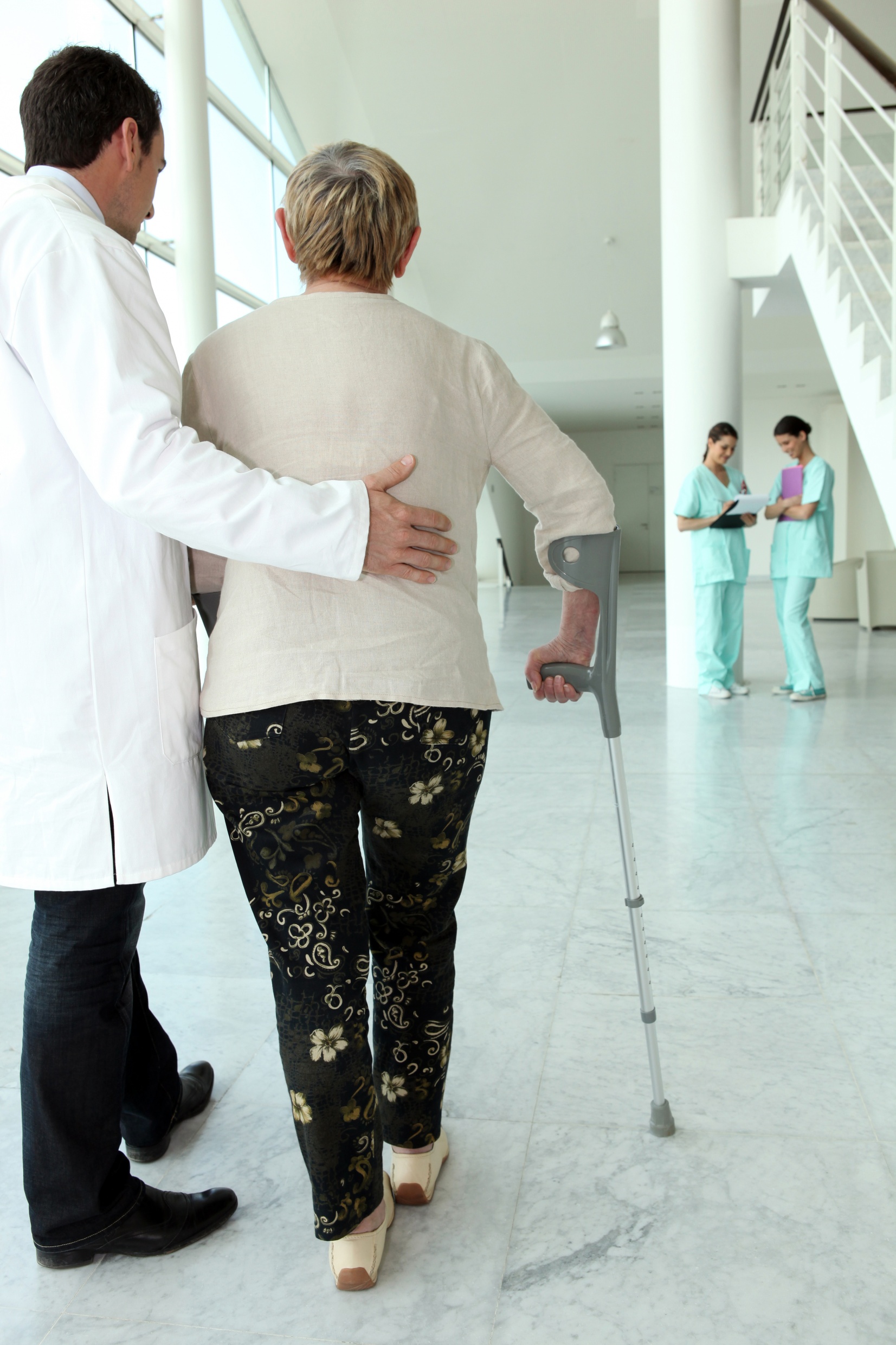 médecin aidant une personne âgée à marcher