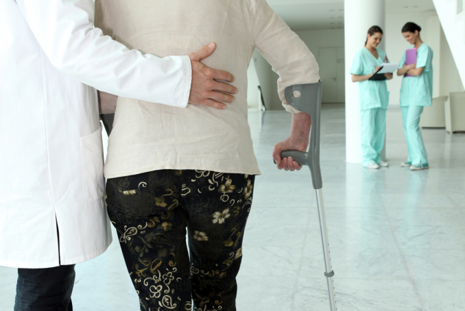 médecin aidant une personne âgée à marcher 