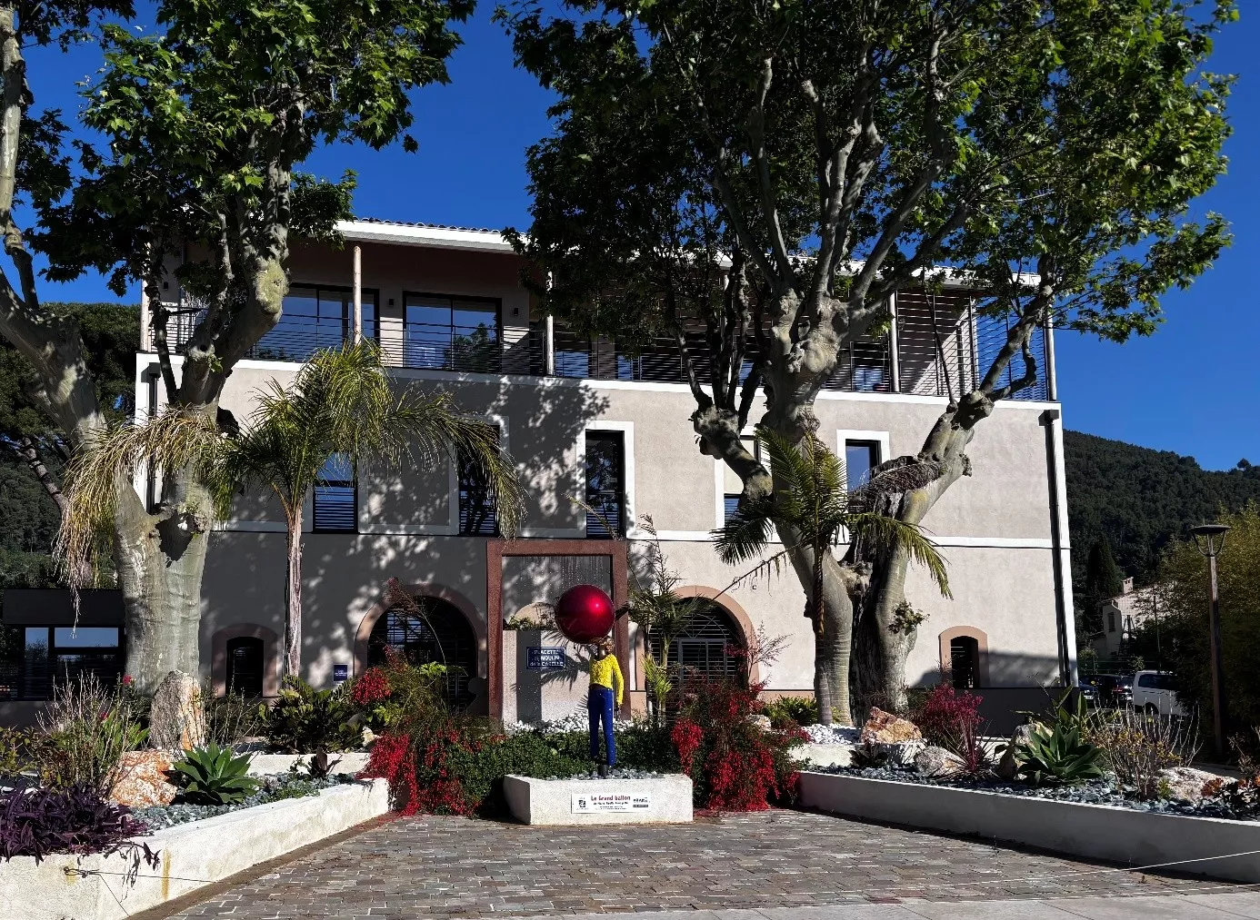batiment moderne avec des arbres et une statue