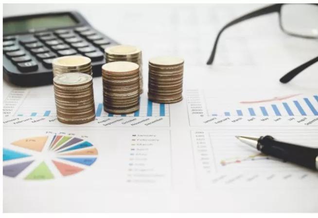 ts de pièces de monnaie posées sur des documents budgétaires